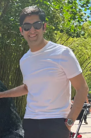 Nayan Seth poses for a photo in front of a tree.