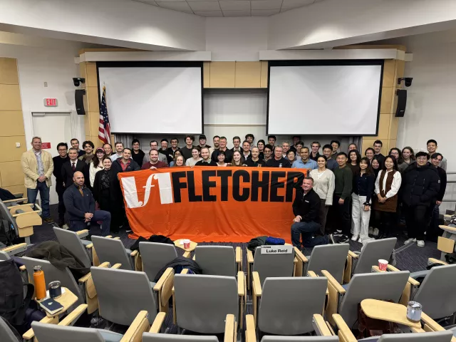 Students in class with The Fletcher School banner