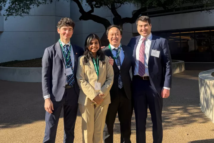 Fletcher students smile for a photo outside of a building.