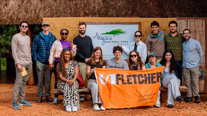 Students pose with the Fletcher flag in Akagera National Park.