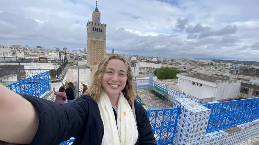 A Fletcher student takes a selfie outside on a rooftop overlooking the city.