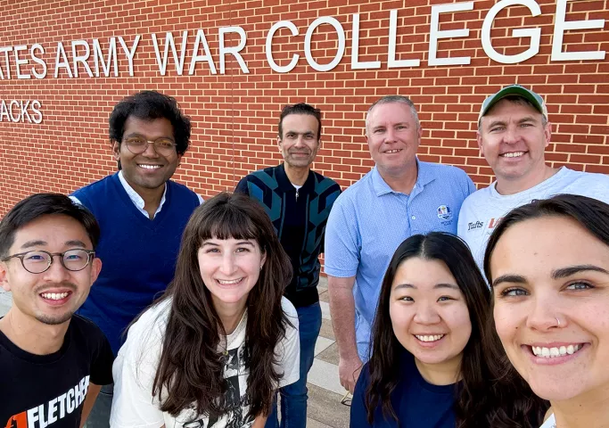 Fletcher students pose for a photo outside a plaque for the United States Army War College.