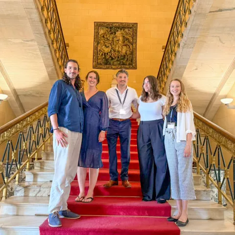 Pablo Zaburlin poses for a photo with other people on a staircase.