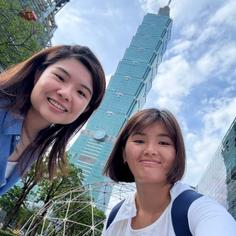 Riley Liu poses with a colleague in front of a building in Taipei.