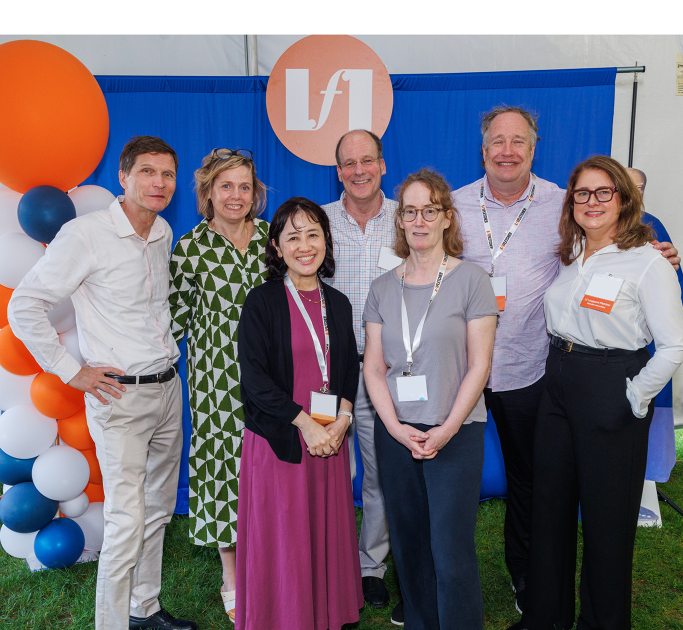 seven people smile for a photo