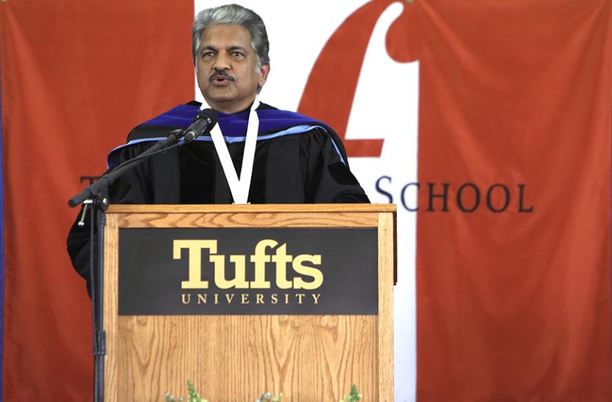 Anand Gopal Mahindra standing at a podium in front of an orange and white Fletcher flag