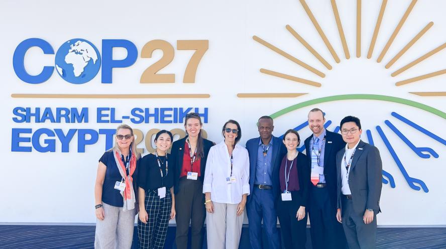 Fletcher's delegation to COP27 poses in front of the conference sign. 