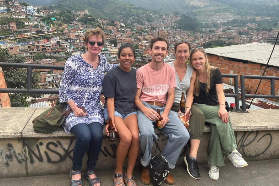 Kim Wilson and four Fletcher students are seated with Medellin depicted in the background.