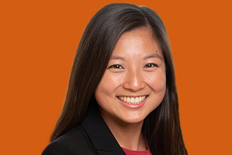 A headshot of Joey Ching in front of an orange background