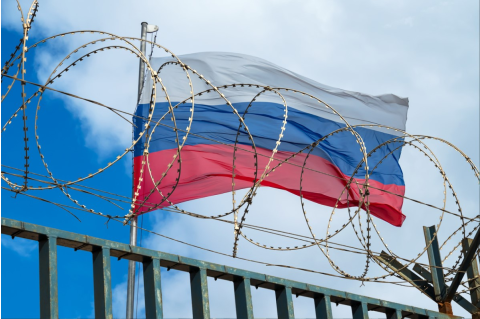 Russia flag behind barb wire fence