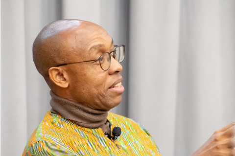 A headshot of Chidi Odinkalu speaking in front of a gray background