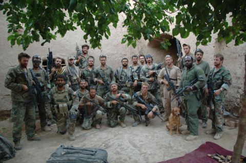 A large group of U.S. Marines with heavy weaponry standing in a dusty courtyard in Afghanistan in 2008. In a new book, writer and former Marine Elliot Ackerman, a Tufts alum, describes America’s chaotic departure from Afghanistan, and his own lessons