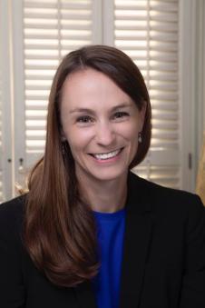A headshot of Sheena Greitens in front of a closed window.