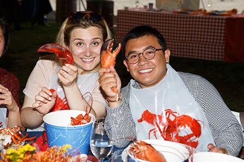 Two alumni members eating lobster