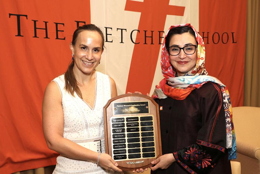 Guadalupe Phillips wearing white dress, and Adela Raz wearing black suit