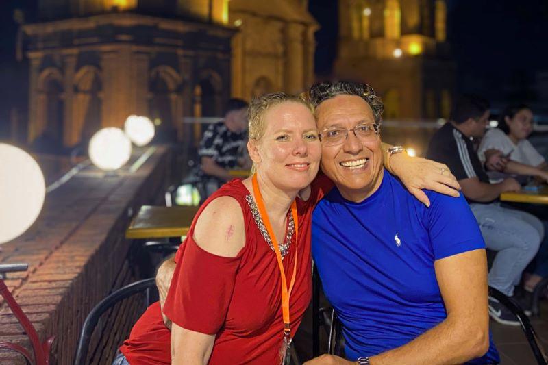 Pedro C. Moreno and wife Rael pose for a photo outdoors at night.