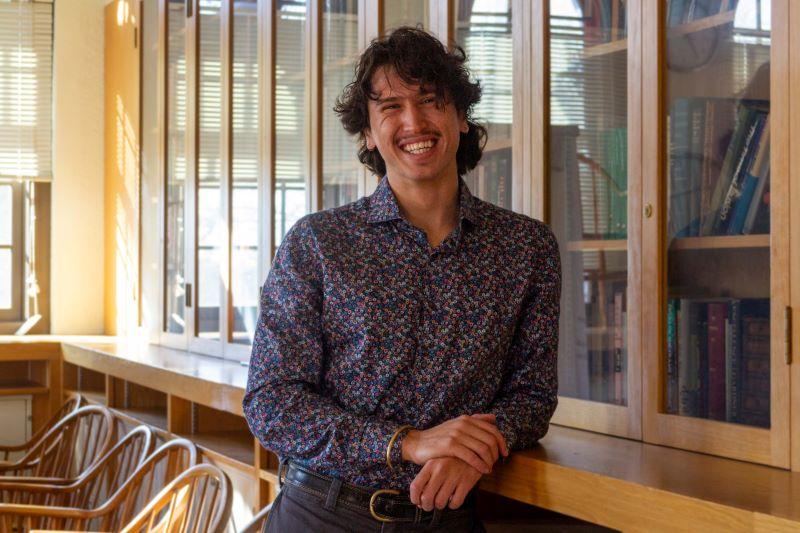 Paolo Caglioti smiles in front of a bookcase.
