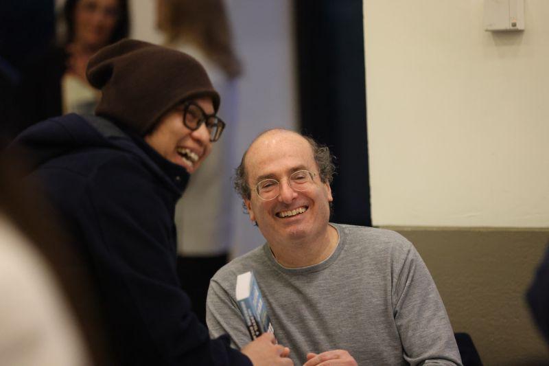 David Grann smiles with a student who is holding one of his books.
