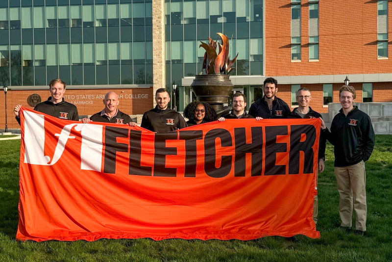 The Fletcher School's team holds the school banner at the fourth annual U.S. Army War College Strategy Competition.