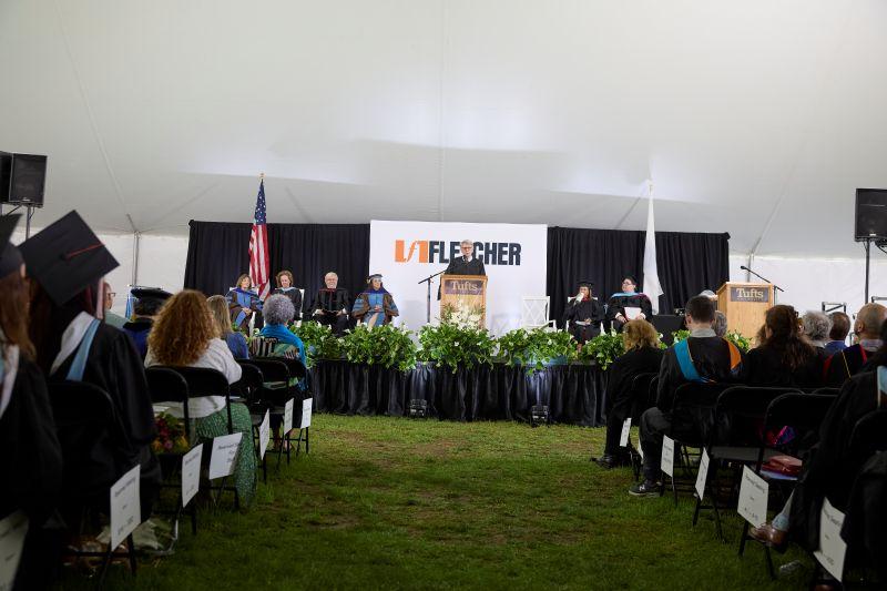 Michael J. Glennon stands at a podium in front of a Fletcher banner, giving his Commencement address.