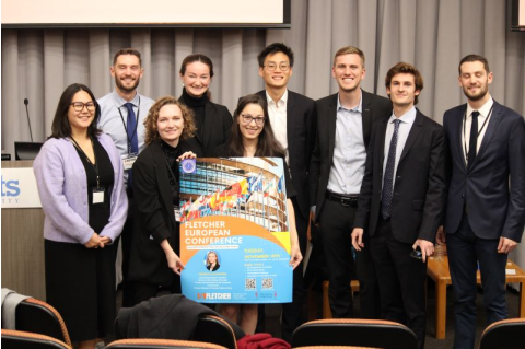 Student participants at the European Conference pose for a picture, holding the conference poster. 
