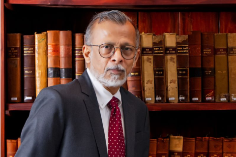 A headshot of Arittha Wikramanayake in front of a bookshelf