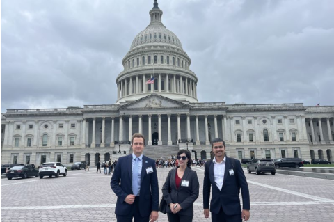 Sam Bowers stands in front of the U.S. Capitol with two other people.