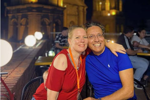Pedro C. Moreno and wife Rael pose for a photo outdoors at night. 
