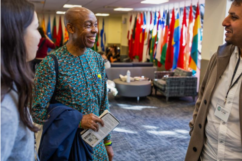 Chidi Odinkalu speaks with two students in the Hall of Flags. 