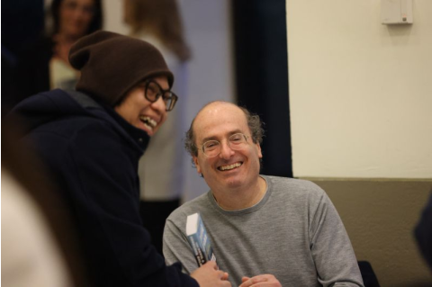 David Grann smiles with a student who is holding one of his books.
