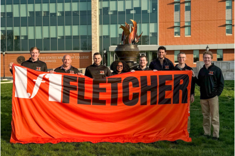 The Fletcher School's team holds the school banner at the fourth annual U.S. Army War College Strategy Competition.