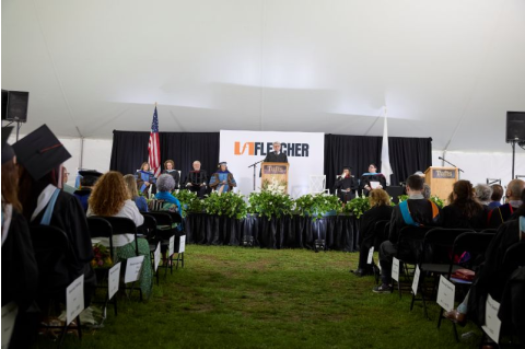 Michael J. Glennon stands at a podium in front of a Fletcher banner, giving his Commencement address.